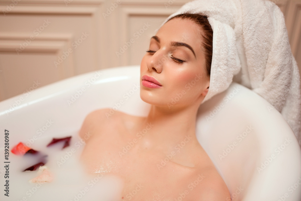 Woman in bathroom with rose petals Woman in bathroom with rose petals