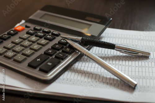 Accounting documents, pens and calculator closeup photo