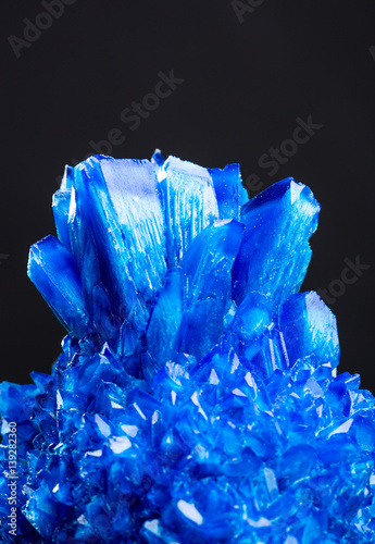 Blue salt crystal isolated on black background photo