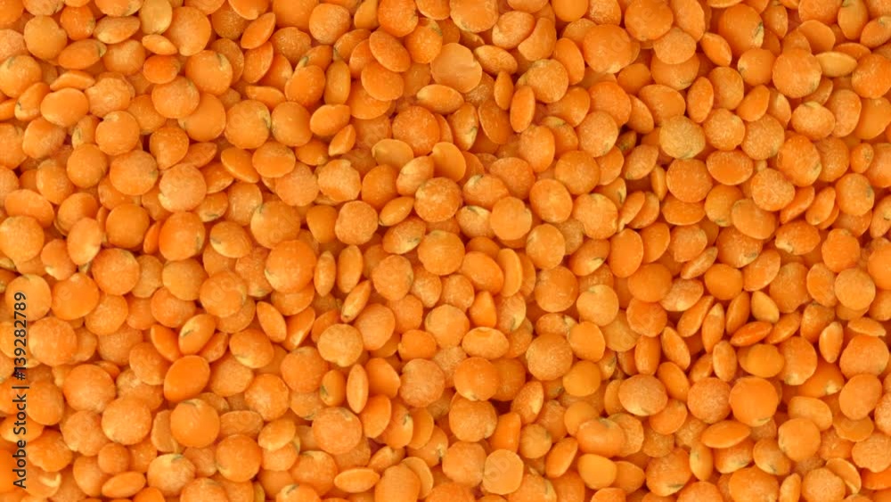 Red lentil rotation background. Healthy raw organic yellow lentils closeup Red lentil rotation background. Healthy raw organic yellow lentils closeup