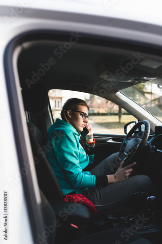 Woman driving a car and talking on mobile phone.  © hedgehog94
