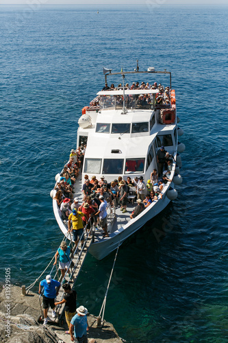 Tourists disembark from a tour boat along the coast of the Cinque Terre, Italy.