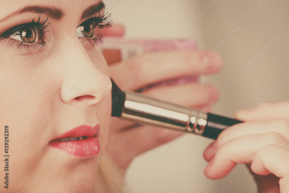 Woman getting her makeup done with professional brush