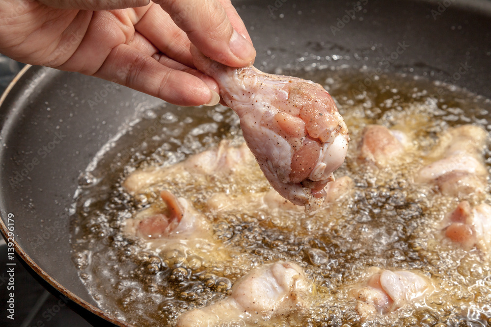 Chef is cooking fried chicken wings in the pan