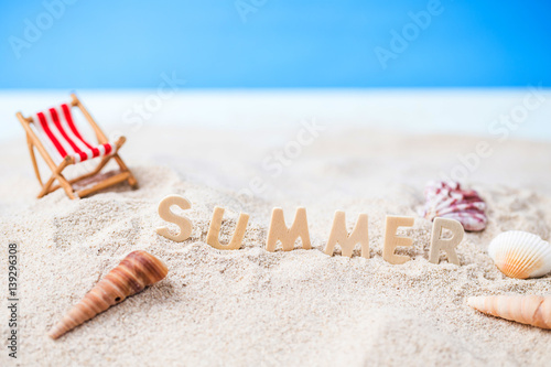 Fototapeta Naklejka Na Ścianę i Meble -  Summer holiday decoration with wooden text, beach chair and sea shall on white sand beach with tropical blue sea and clear blue sky,Image For Love summer holiday vacation travel Concept.