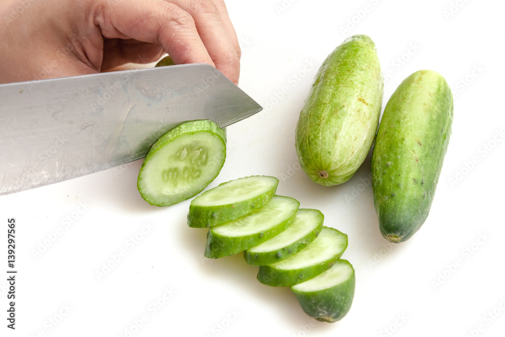 Cutting cucumbers into small slices on white background isolated