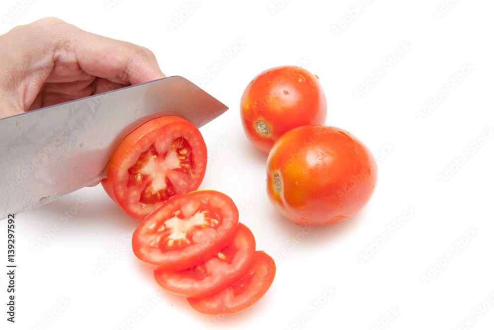 Cutting tomatoes into small slices on white background isolated