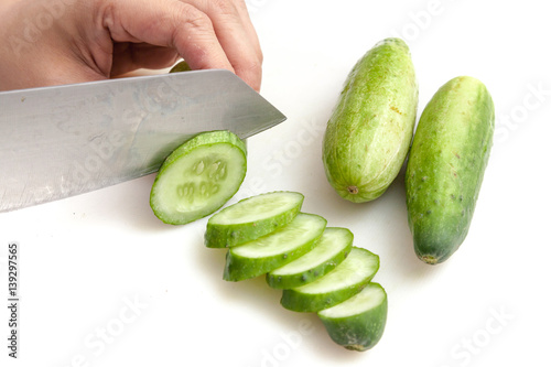 Obraz na płótnie Cutting cucumbers into small slices on white background isolated w salonie