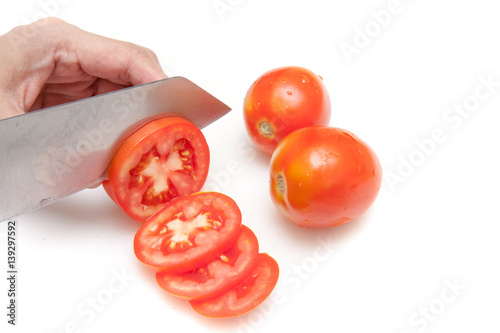 Obraz na płótnie Cutting tomatoes into small slices on white background isolated w salonie