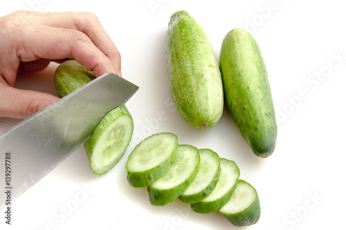 Obraz na płótnie Cutting cucumbers into small slices on white background isolated w salonie