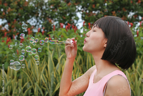 Young asian woman playing bubble on the roof top of building.