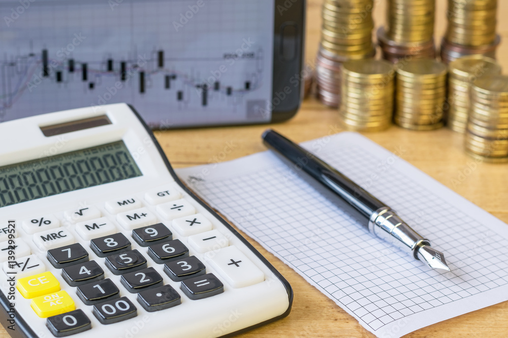 Metal coins and calculator on a rustic table. Metal coins and calculator on a rustic table.