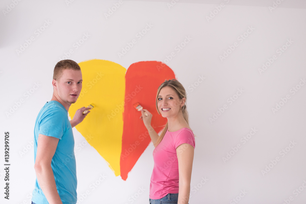 couple are painting a heart on the wall couple are painting a heart on the wall