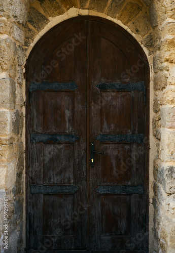 A brown old wooden door on grunge brick wall in the centre of Baku Azerbaijan