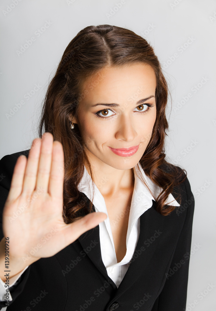 Businesswoman with stop gesture, over grey Businesswoman with stop gesture, over grey