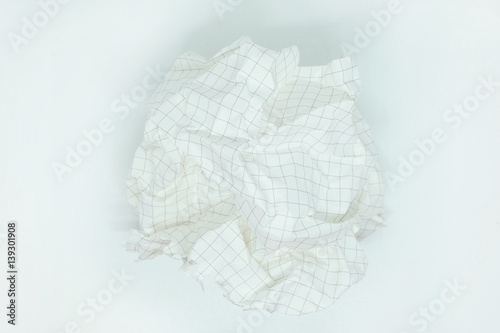 close up of a  crumpled grid paper on white background