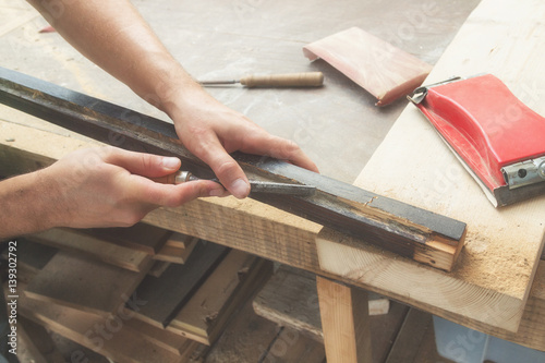 Carpenter working on the raw board / wood.