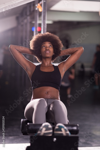 Fototapeta Naklejka Na Ścianę i Meble -  black woman doing sit ups at the gym