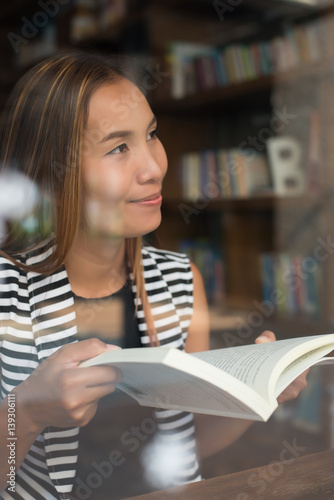 Asian woman reading a book in library. photo