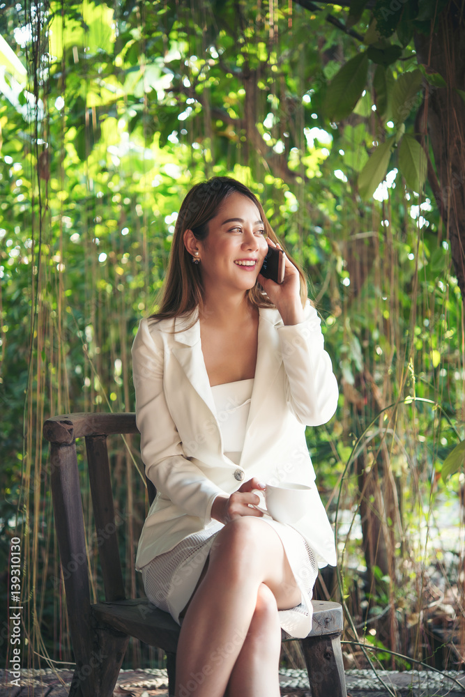 Young beautiful business woman talking on phone outside. Young beautiful business woman talking on phone outside.