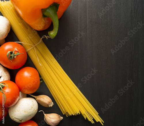 Food ingredients for Italian spaghetti on a black background with lot of copy space for your project.
