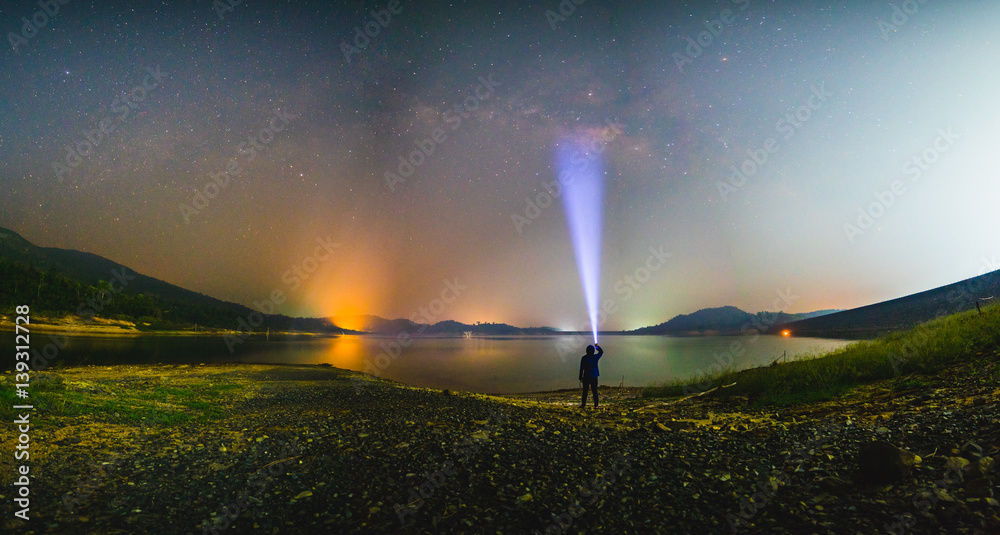 Silhouette man with flashlight and Milky way galaxy at lake - obrazy, fototapety, plakaty 