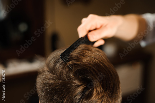 Master cuts hair and beard of men in the barbershop