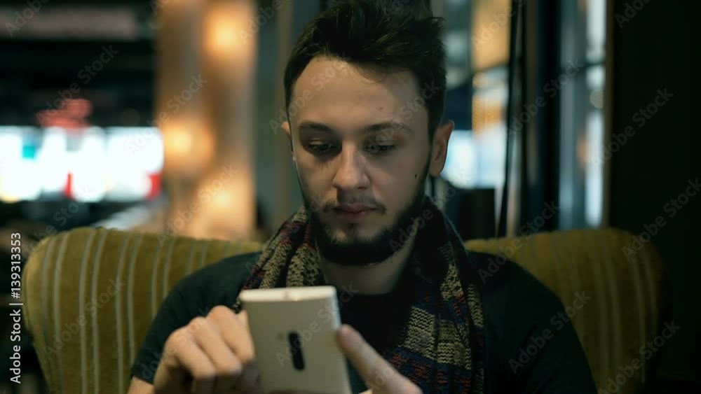 Absorbed boy sitting on the armchair in the cafe and browsing internet on smartphone
Absorbed boy sitting on the armchair in the cafe and browsing internet on smartphone