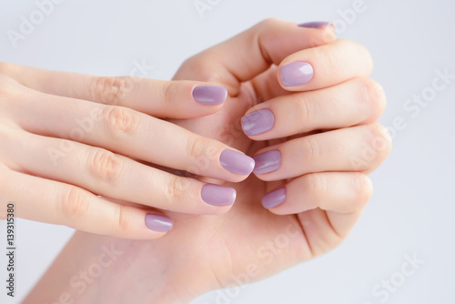 Closeup of hands of a young woman with pink manicure on nails