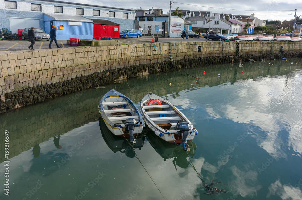 Φωτογραφία Fishing boats reflected in water and utility buildings on the shore in Dublin fi