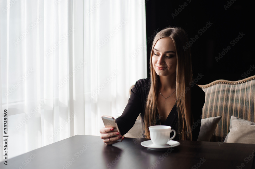 Portrait of young businesswoman use mobile phone while sitting in comfortable coffee shop during work break Portrait of young businesswoman use mobile phone while sitting in comfortable coffee shop during work break