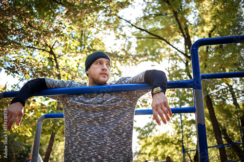 Healthy handsome active man with fit muscular body doing workout exercises. Outdoor, park. Sports and fitness concept photo