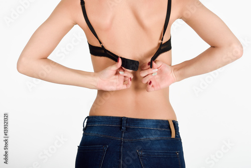 Woman unhooking the clasp of her black bra