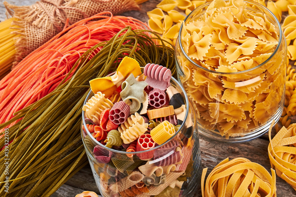 Many different beautiful pasta in glass jars.