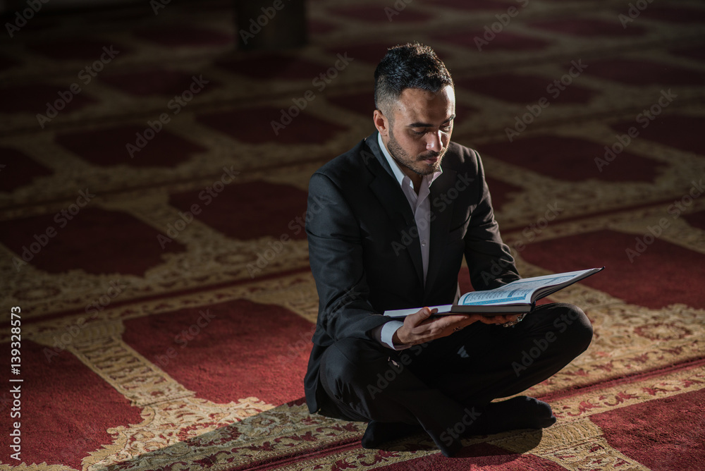 Fototapeta premium Elegant business man studying holy book Koran