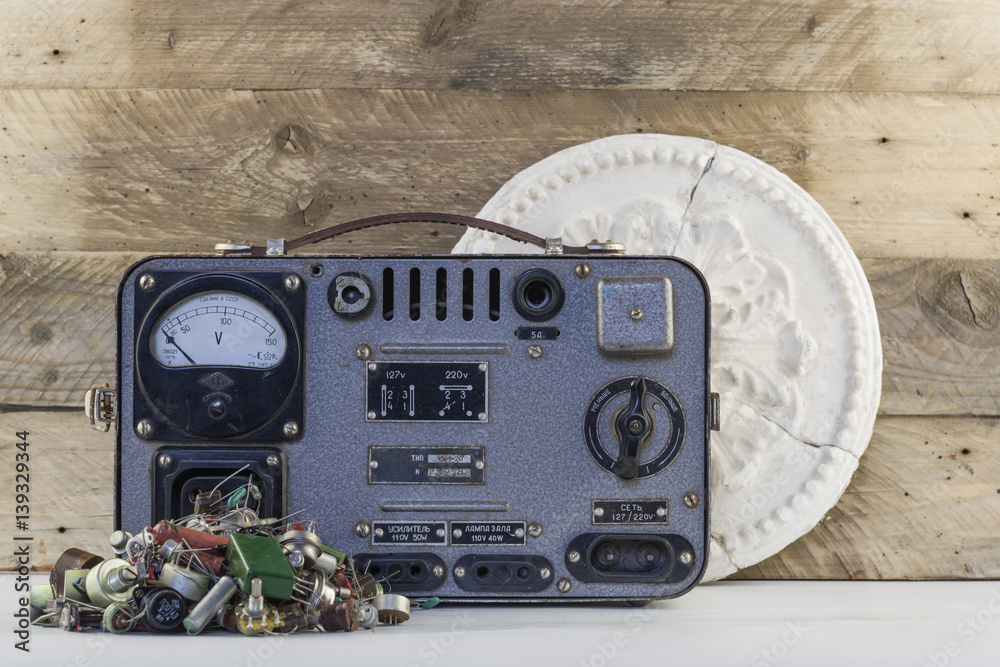 Vintage voltage regulator with transistors, resistors, radio parts and old  plaster rosette wood backgraund Stock Photo | Adobe Stock