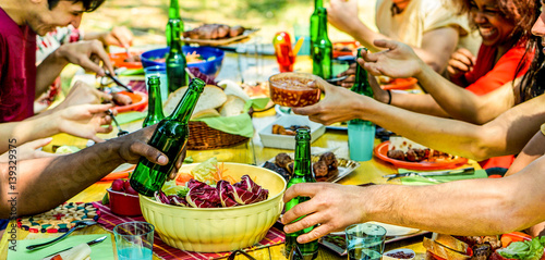 Group of students eating meat and vegetables at barbecue