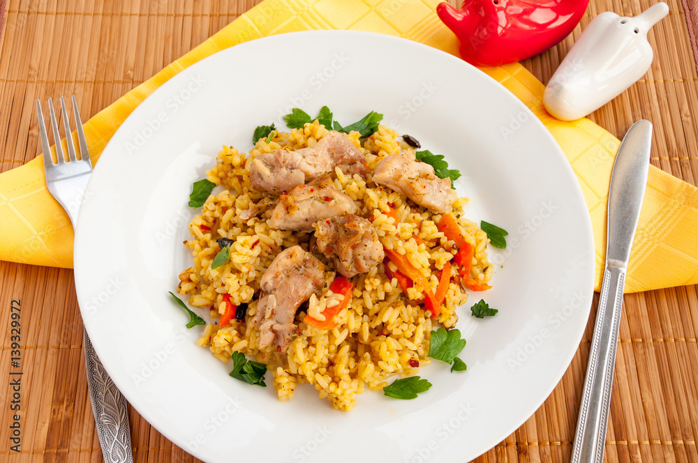 pilaf with meat and vegetables in a white plate