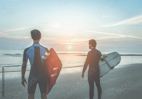 Photography Young surfers waiting the waves on beach with sun light in background - Sport fr