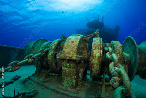 Heavy duty chain and winches that still exist on the forward deck of this sunken ship were used to raise the anchor. The vessel now lies beneath the sea in warm shallo water in Grand Cayman. photo