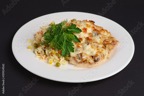 chicken fillet with mushrooms and cheese garnished with rice, corn and peas