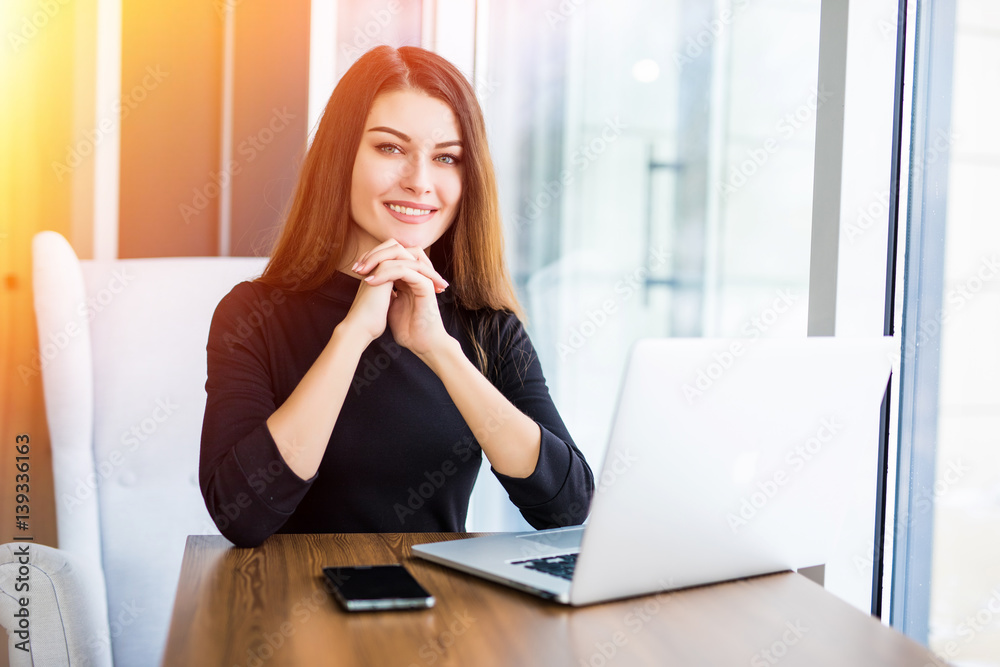 Beautiful woman working on her laptop on a stylish urban restaurant Beautiful woman working on her laptop on a stylish urban restaurant