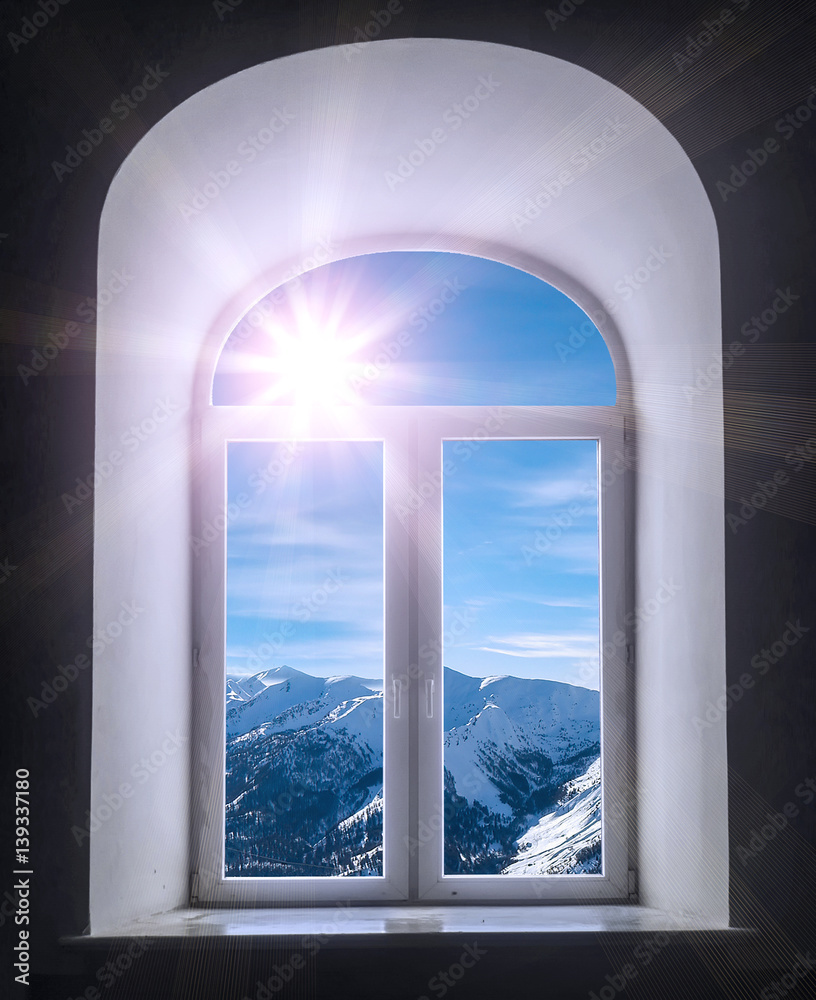 white semicircular modernist windows on a black wall.winter, sky, clouds, sun, mountains in the window