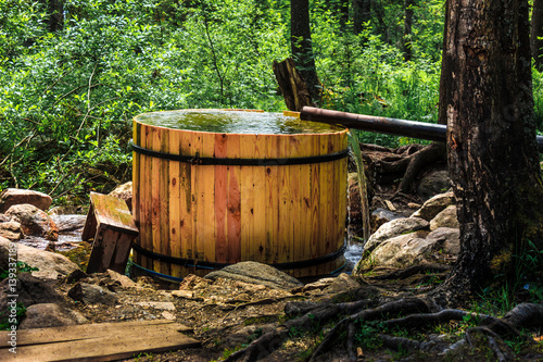 Forest spring water fills a wooden barrel © Alexander