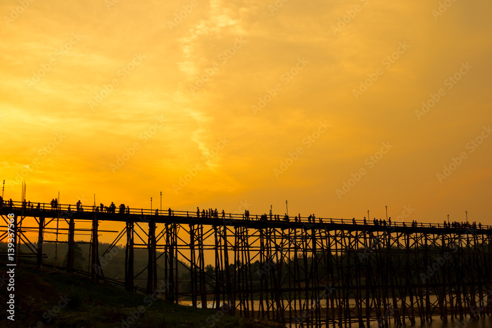 People on the large wooden bridge in the shadows