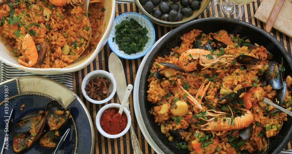 Dolly top down view of delicious Spanish seafood paella: mussels, king prawns, langoustine, haddock