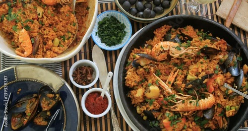 Dolly top down view of delicious Spanish seafood paella: mussels, king prawns, langoustine, haddock