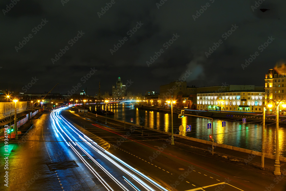 embankment of the Moscow night, the darkness with trails of light from cars.