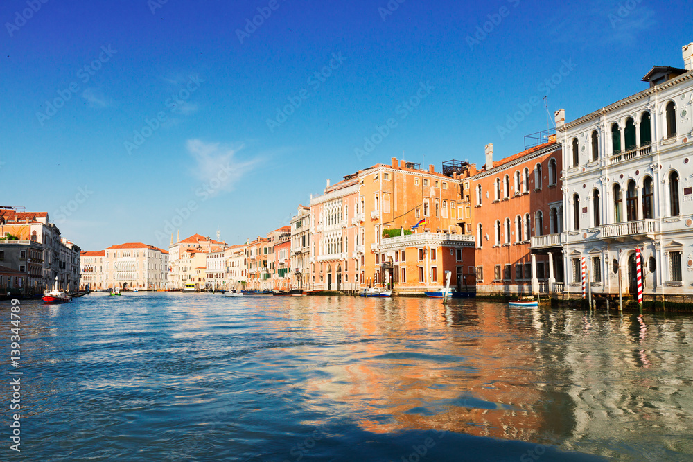 muticolored Venice houses and reflections over water of Grand canal with boats, Italy