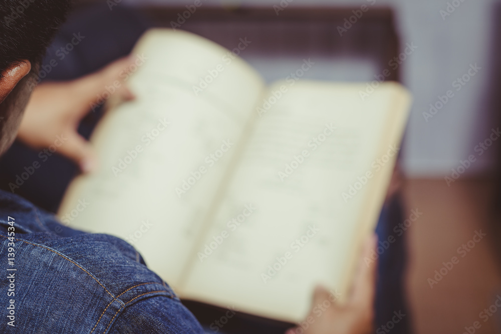 Fototapeta premium Young man reading a book
